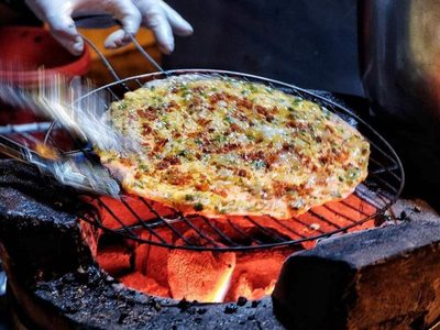 Du khách thưởng thức bánh tráng nướng ở chợ đêm Đà Lạt