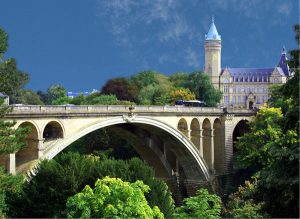 Toàn cảnh thành phố Luxembourg từ trên cao với những tòa nhà cổ kính và cây xanh tươi tốt.