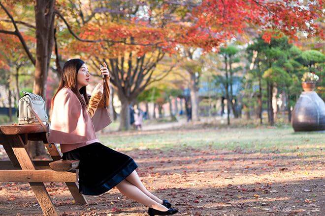 Du khách mặc áo khoác nhẹ dạo chơi trong nắng thu Hàn Quốc